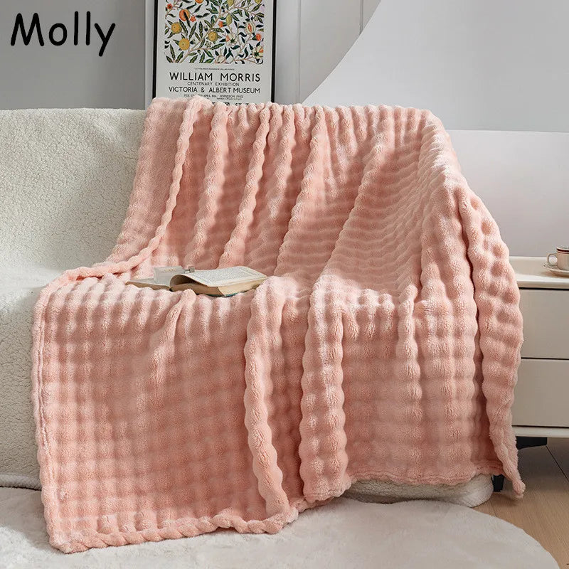Pink PlushBubble extra soft flannel blanket draped over a sofa