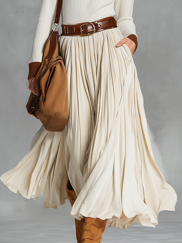 Model wearing a pleated beige midi skirt with brown accessories