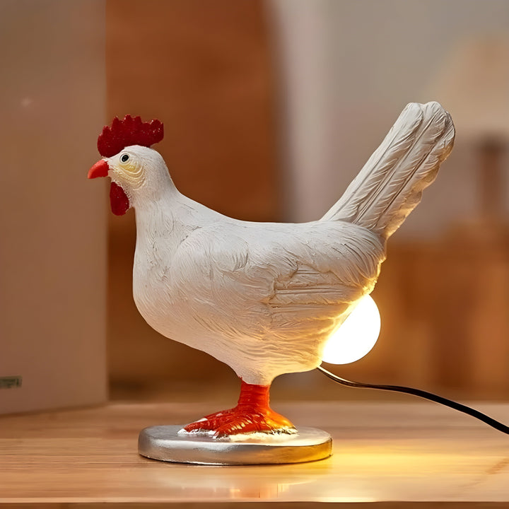 Novelty chicken table lamp emitting warm LED light on a wooden surface