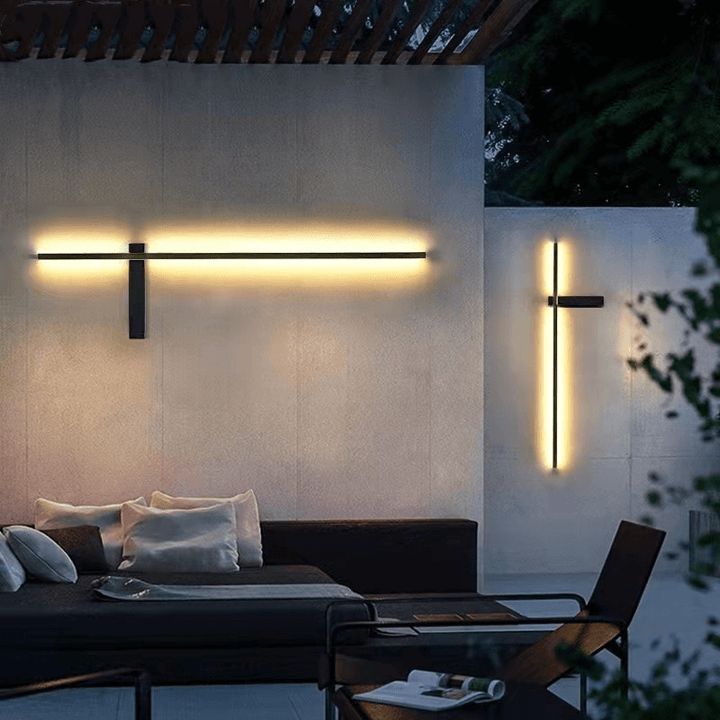 Modern outdoor LED wall lamp mounted on a patio wall emitting warm light