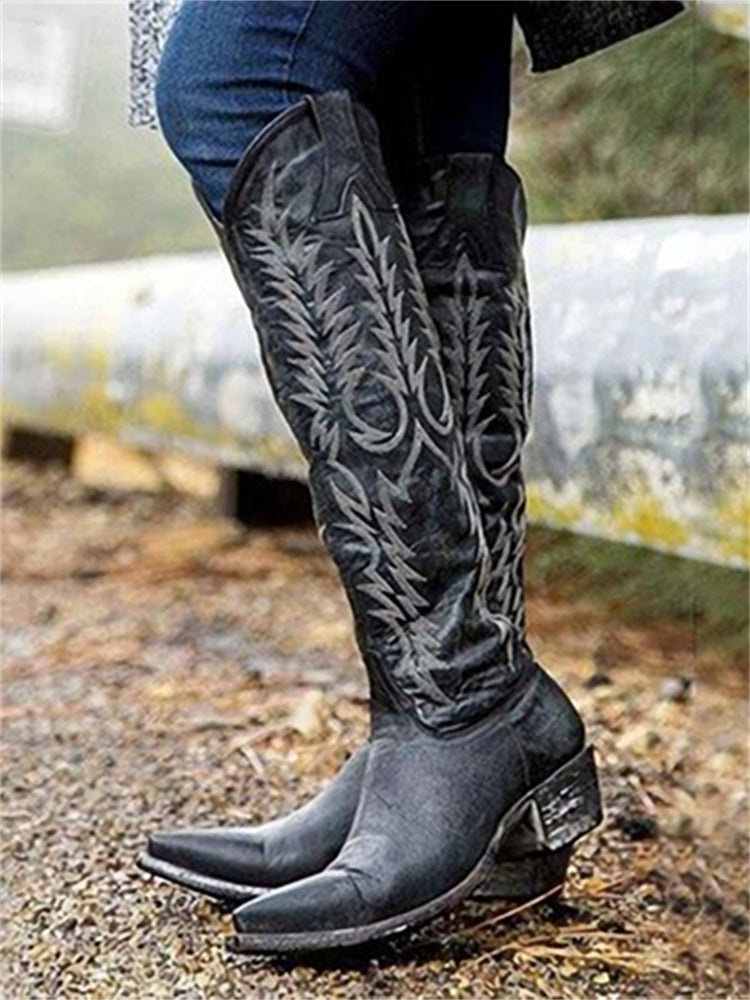 Black knee-high western boots styled with jeans outdoors