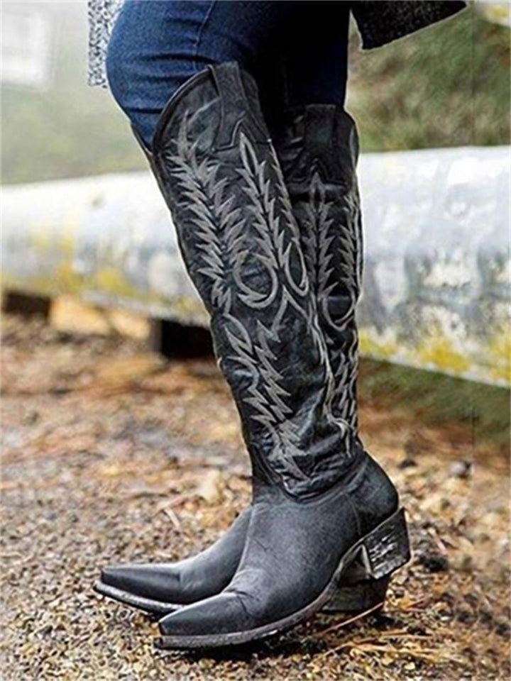 Black knee-high western boots styled with jeans outdoors