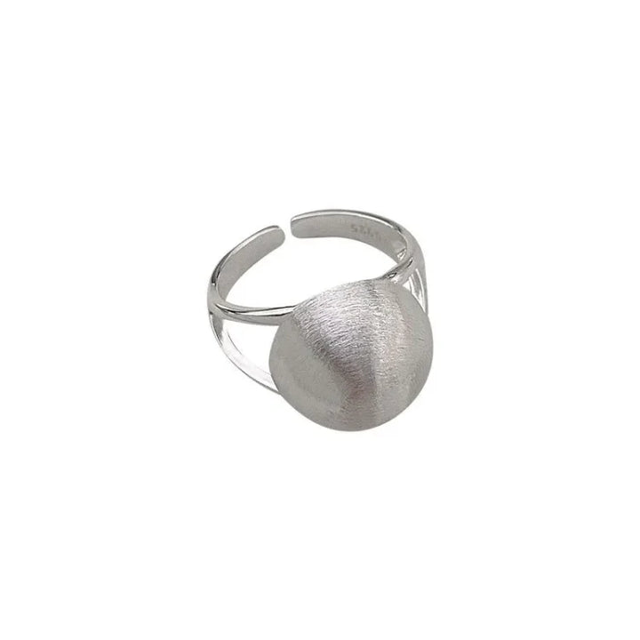 Studio shot of a silver half-dome ring with a brushed texture on a white background