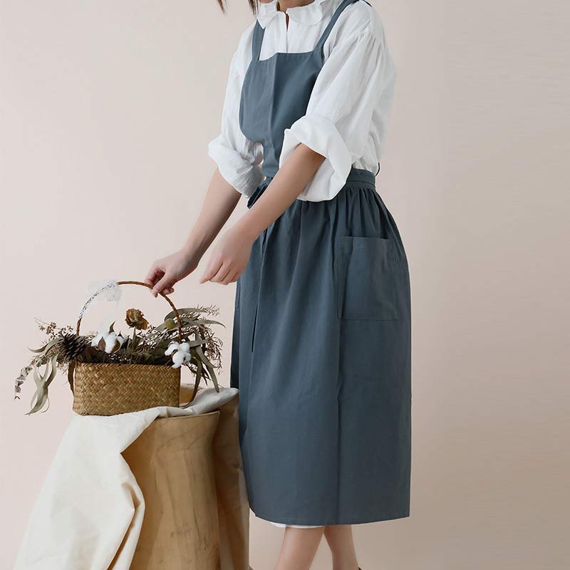 Beige cooking apron featuring durable waterproof fabric and dual pockets