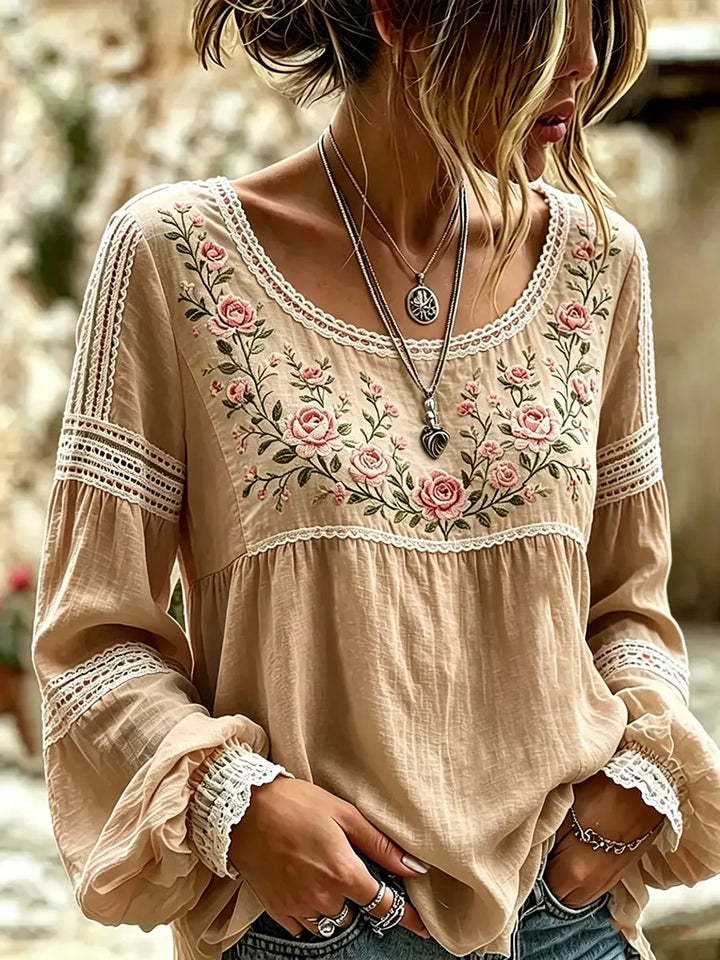 Close-up view of vibrant floral embroidery on the sleeve of a casual womens top