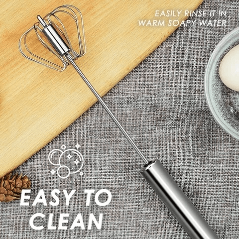 Stainless steel whisk whipping cream in a mixing bowl