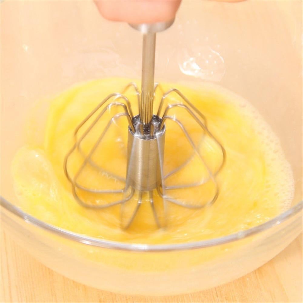 Kitchen hand mixer whisk lying flat beside baking ingredients