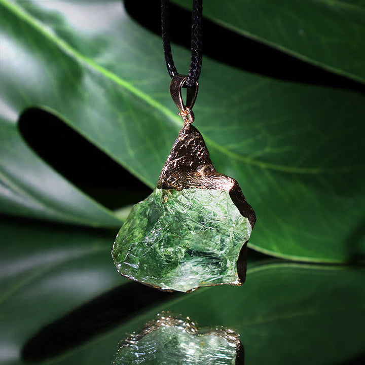 Close-up view of the raw green moldavite gemstone pendant and adjustable cord