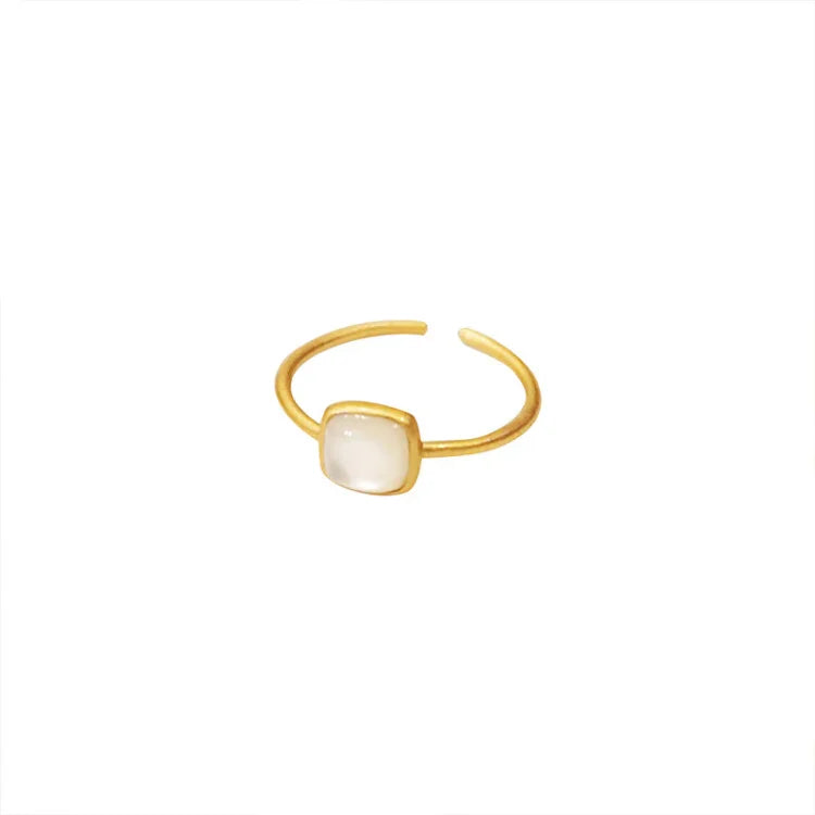 White vintage enamel ring with gold plated band on a white background