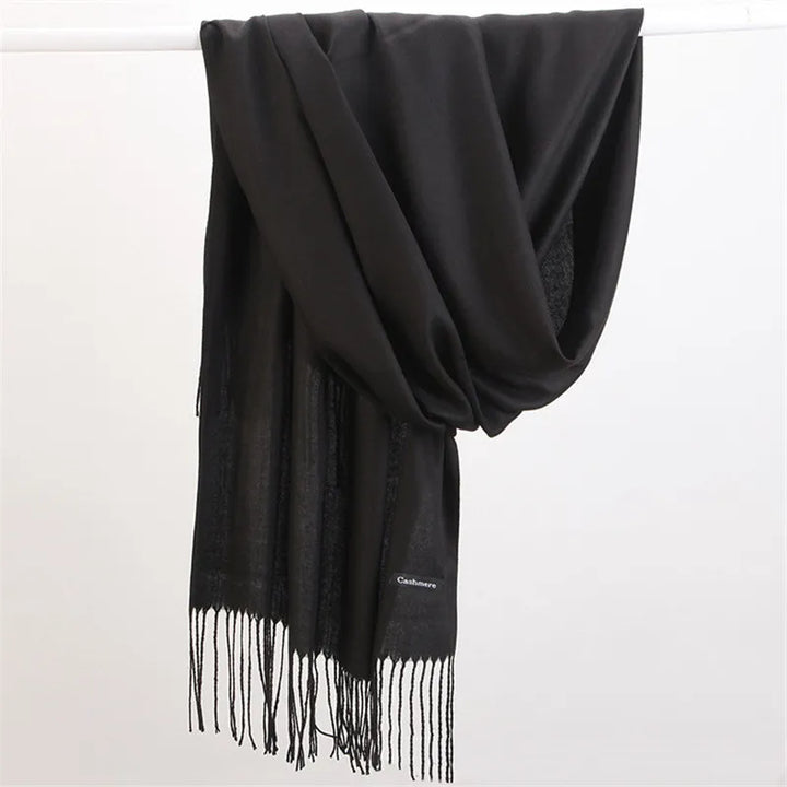 Black Faith winter scarf draped over a display bar with fringe details