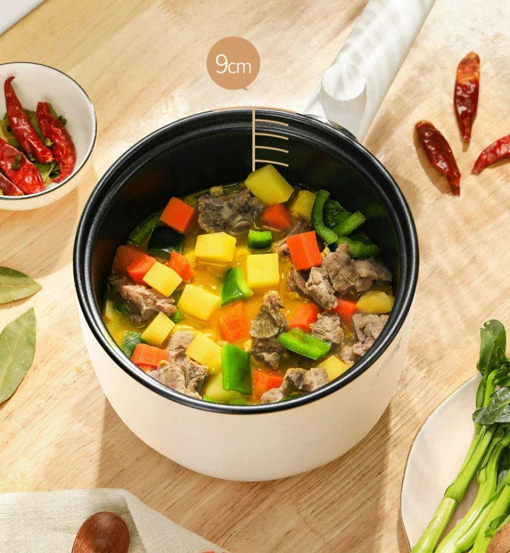 Multifunctional pot with steamer tier preparing vegetables and dumplings
