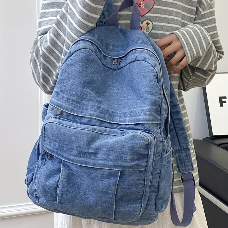 Blue denim travel bag worn by a model showcasing its comfortable straps and size