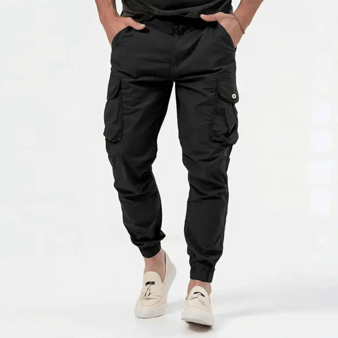 Man wearing black Fenix cargo jogger tapered pants with snap pockets