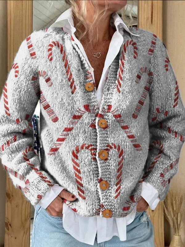Front view of a woman wearing a festive candy cane pattern buttoned cardigan sweater over a white collared shirt and jeans.