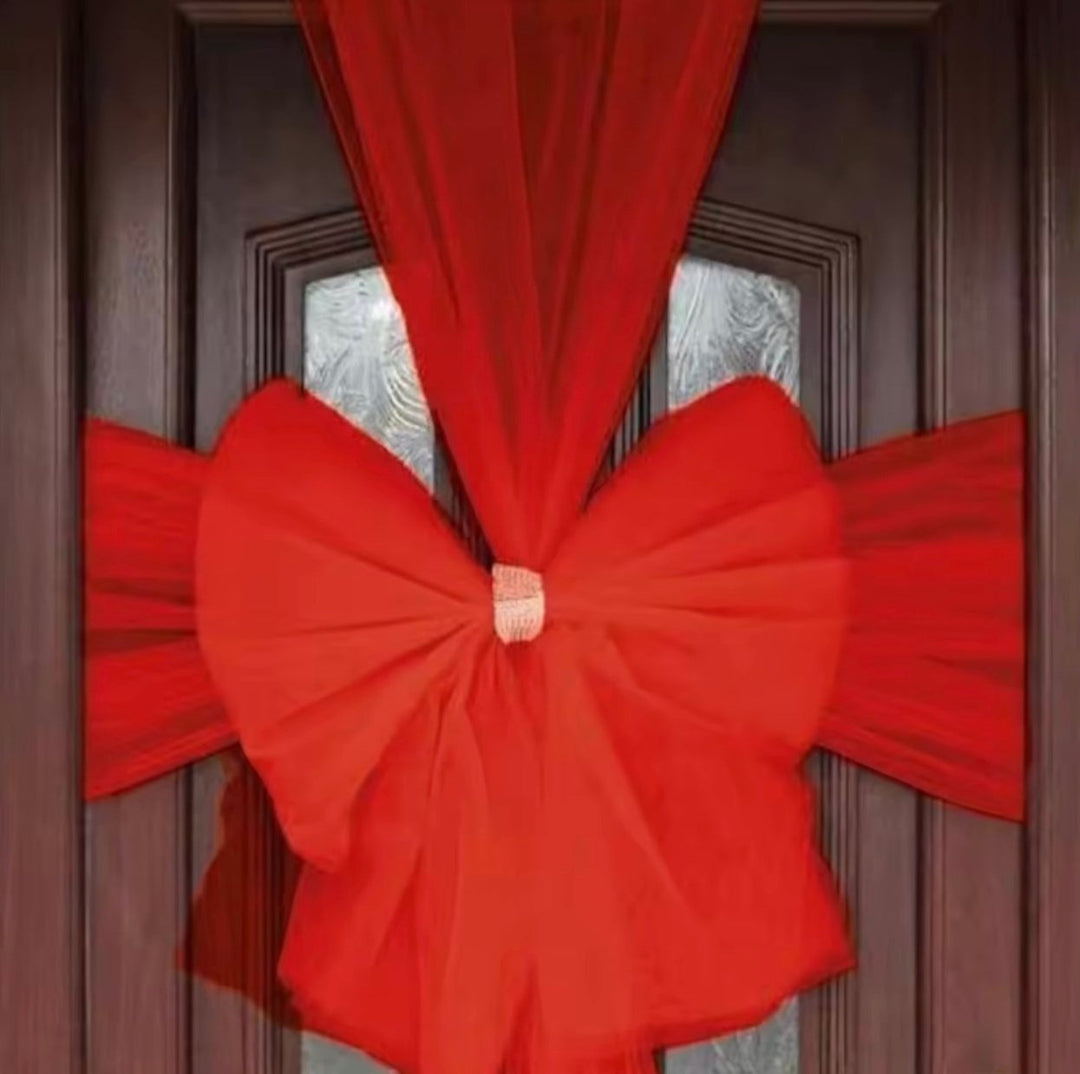 Close-up view of the vibrant red door bow and decorative center knot