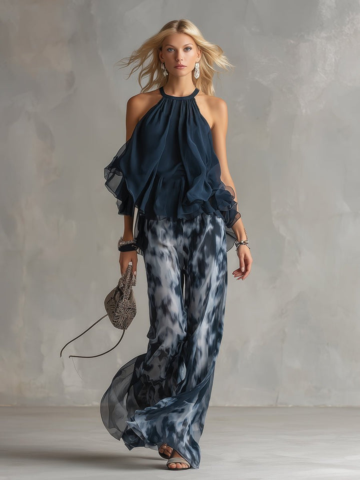 Front view of a model in a navy blue halter neck two piece set with flowing wide leg trousers