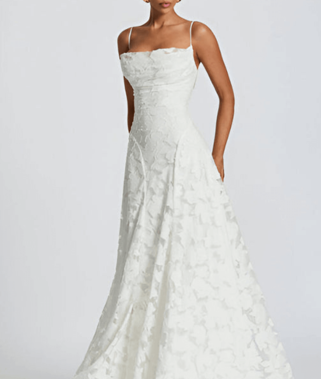 Front view of a woman wearing a white floral maxi dress with spaghetti straps