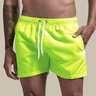 Man wearing neon green men's drawstring swim shorts with side pockets