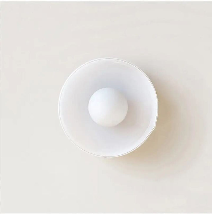 Minimalist indoor glass ceiling light mounted against a neutral white ceiling
