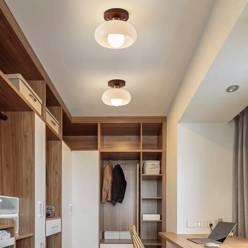 Bauhaus flush mount ceiling light with warm glass shade and wood accent detail