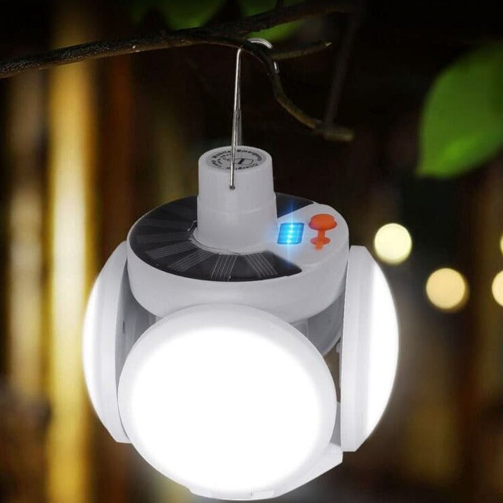 Foldable solar LED camping bulb hanging in a tent as a bright outdoor lamp