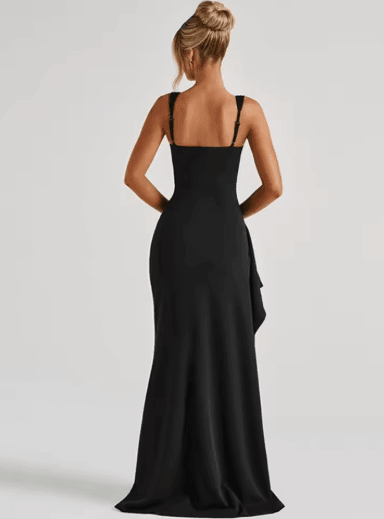 Back view of a woman wearing a black formal maxi dress showing wide straps and fitted silhouette