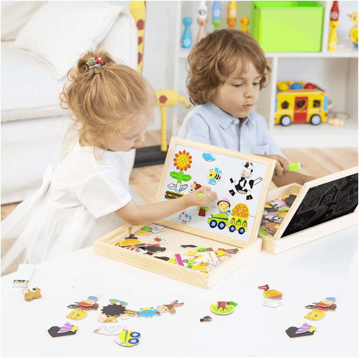 Young girl drawing on the white magnetic board while boy plays nearby