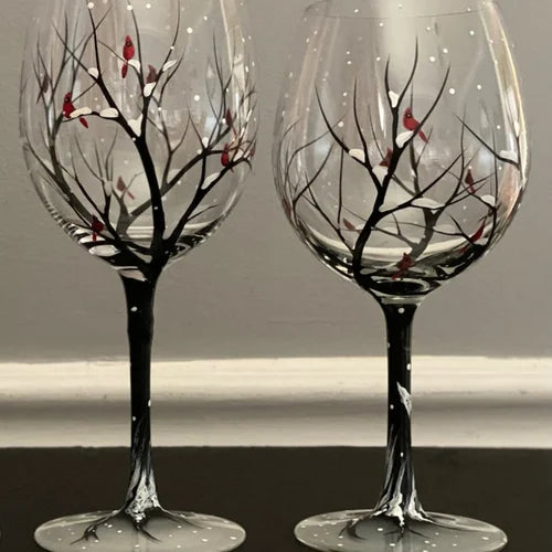 Set of four seasons hand-painted tree wine glasses on a rustic table