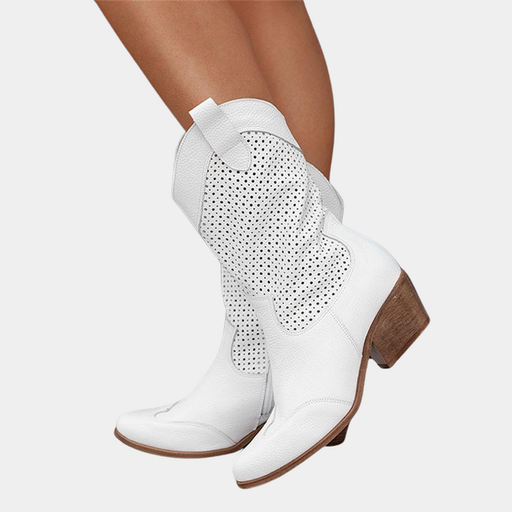 Woman wearing white perforated western ankle boots with block heels