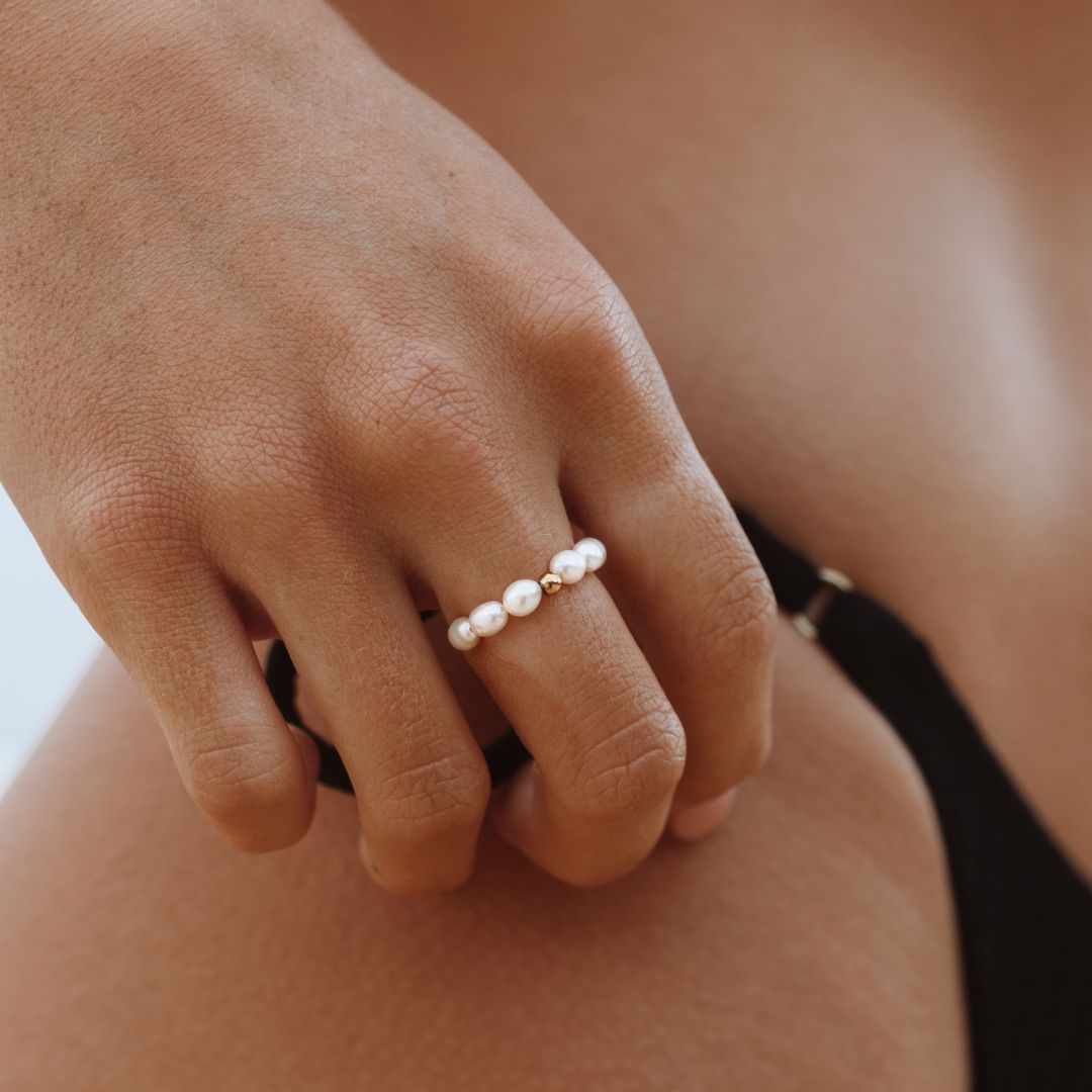 Close-up of a woman wearing an ocean pearl ring on her finger