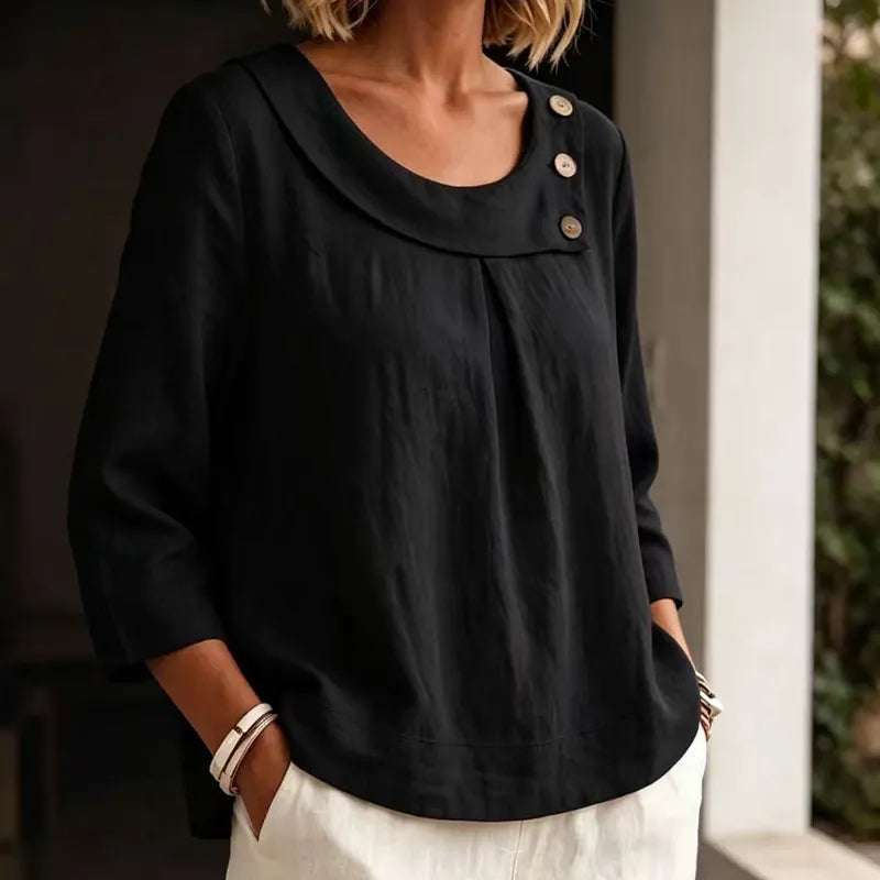 Woman wearing black round neck blouse with button detail and three-quarter sleeves