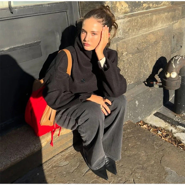 Woman sitting down wearing the stylish black double-breasted winter jacket