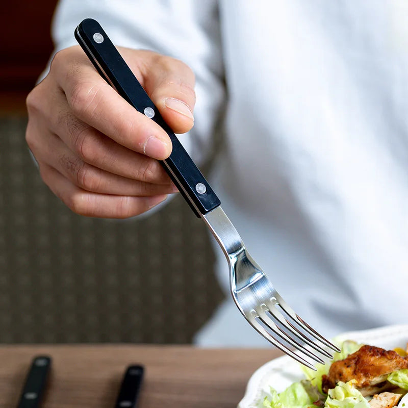 24-piece stainless steel cutlery set neatly arranged on a modern dining table