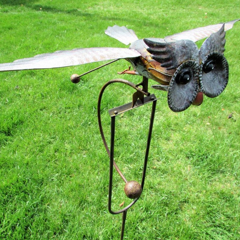 Flying owl kinetic metal sculpture mounted on a garden stake