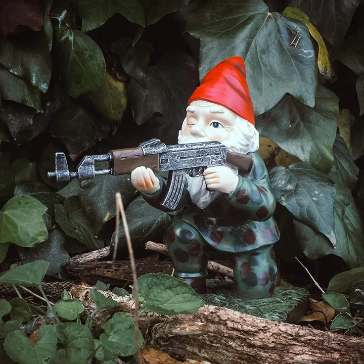 Kneeling military garden gnome statue with rifle outdoors