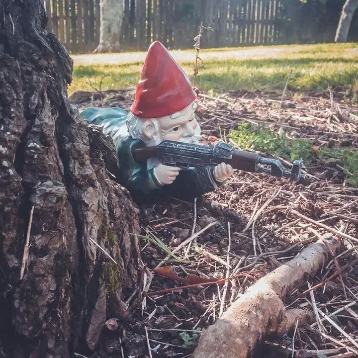 Armed tactical gnome outdoor decor piece standing guard in garden bed