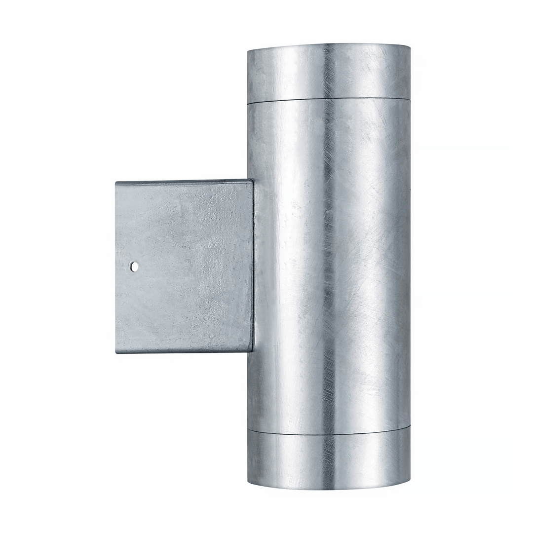 Modern silver up-down outdoor wall lamp illuminating exterior house facade with warm light