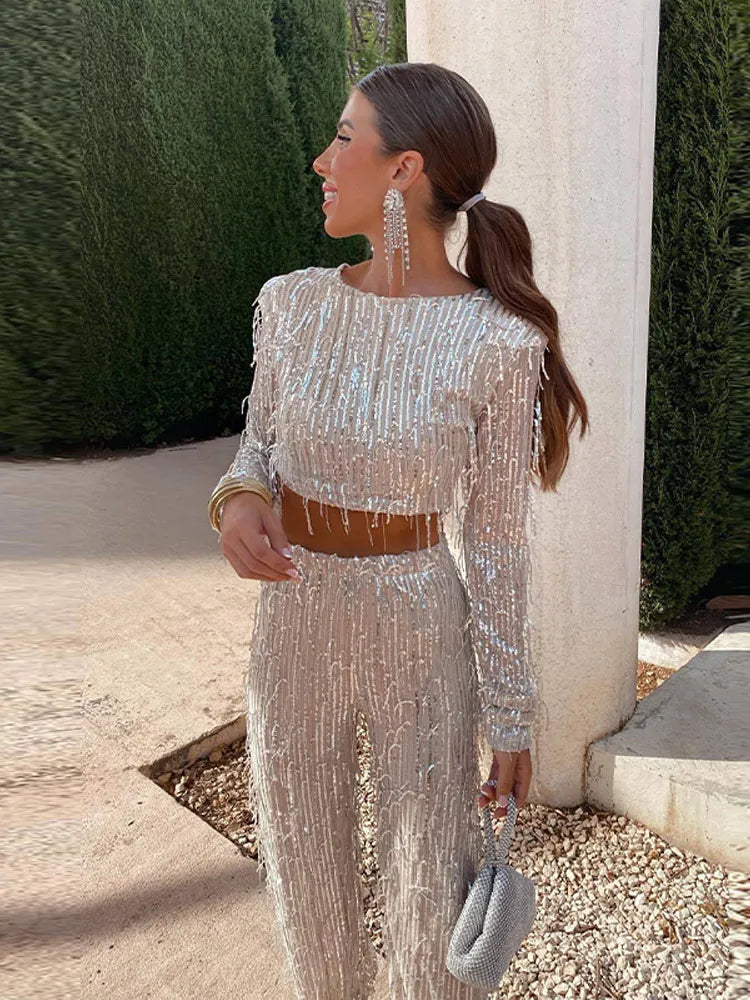 Woman wearing a glamorous sparkling sequin two-piece set with fringe details outdoors