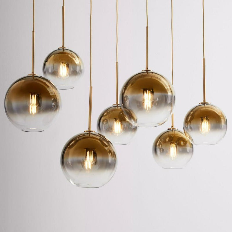 Close-up of spherical glass shade and brass finish on modern ceiling lamp