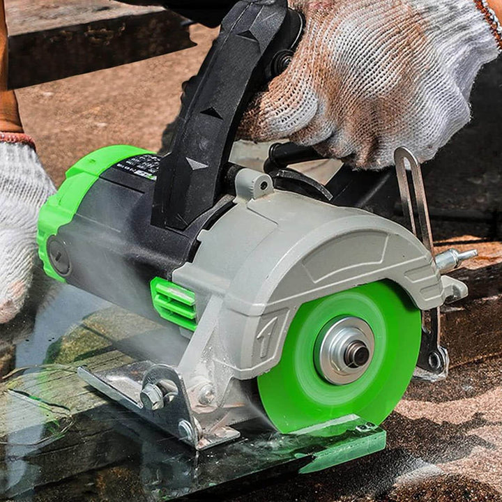 Angle grinder in use with a green glass cutting disc cutting through glass.