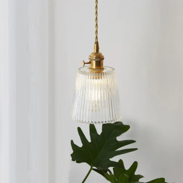 Small fluted glass pendant lamp casting a warm glow downward