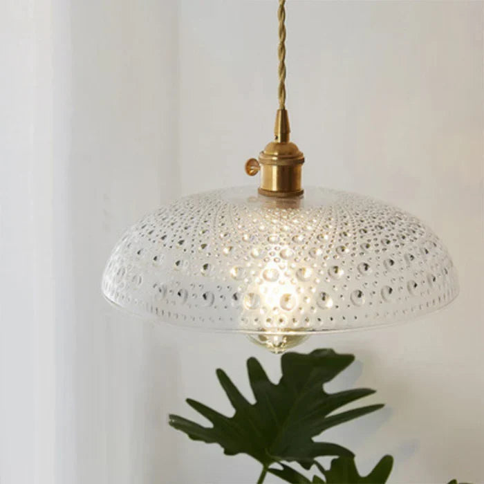 Minimalist dining room decor featuring a stylish glass pendant lamp turned on