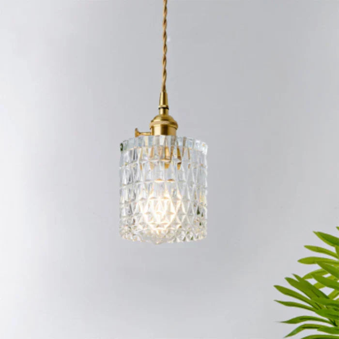 Modern glass pendant lamp hanging over a stylish dining room table for warm lighting