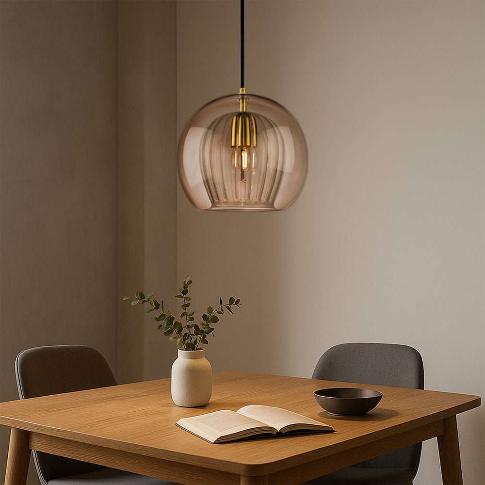 Minimalist glass pendant light illuminating a modern kitchen island