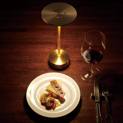 Cordless battery powered lamp illuminating a restaurant dining setting