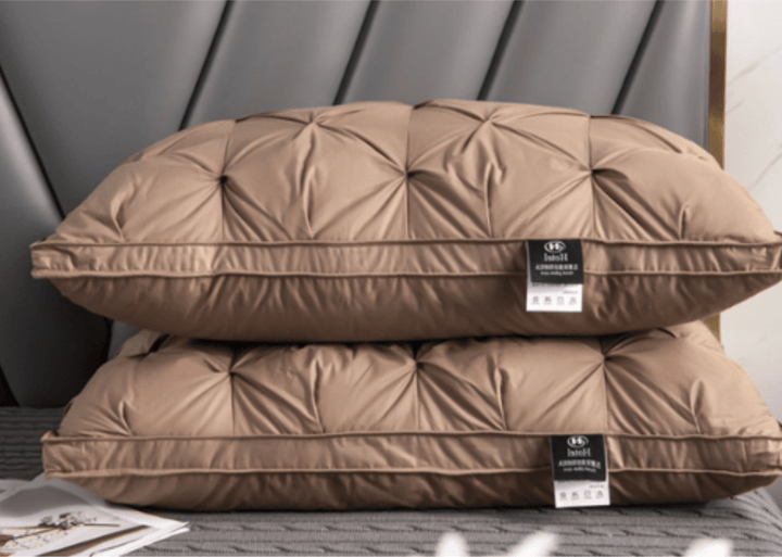 Two elegant brown goose down pillows arranged on a bed with a modern headboard