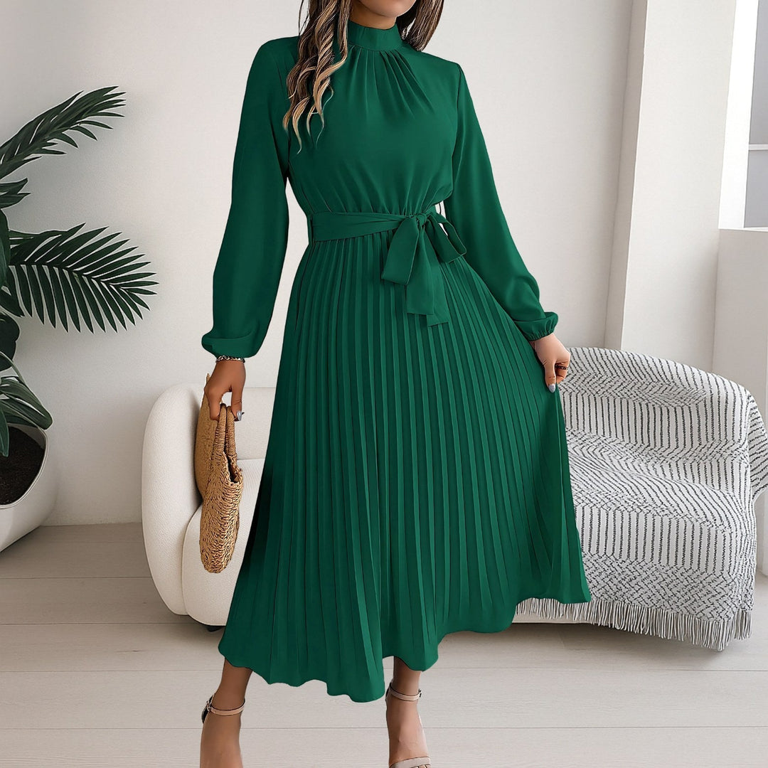 Close-up of the high neckline and pleated bodice on a dark green midi dress