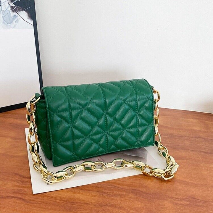 Green jacquard flap handbag resting on table with gold hardware