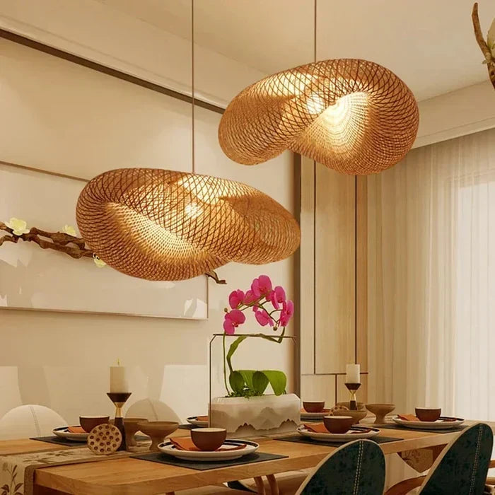 Boho style rattan ceiling lamp hanging above a dining area with floral decor