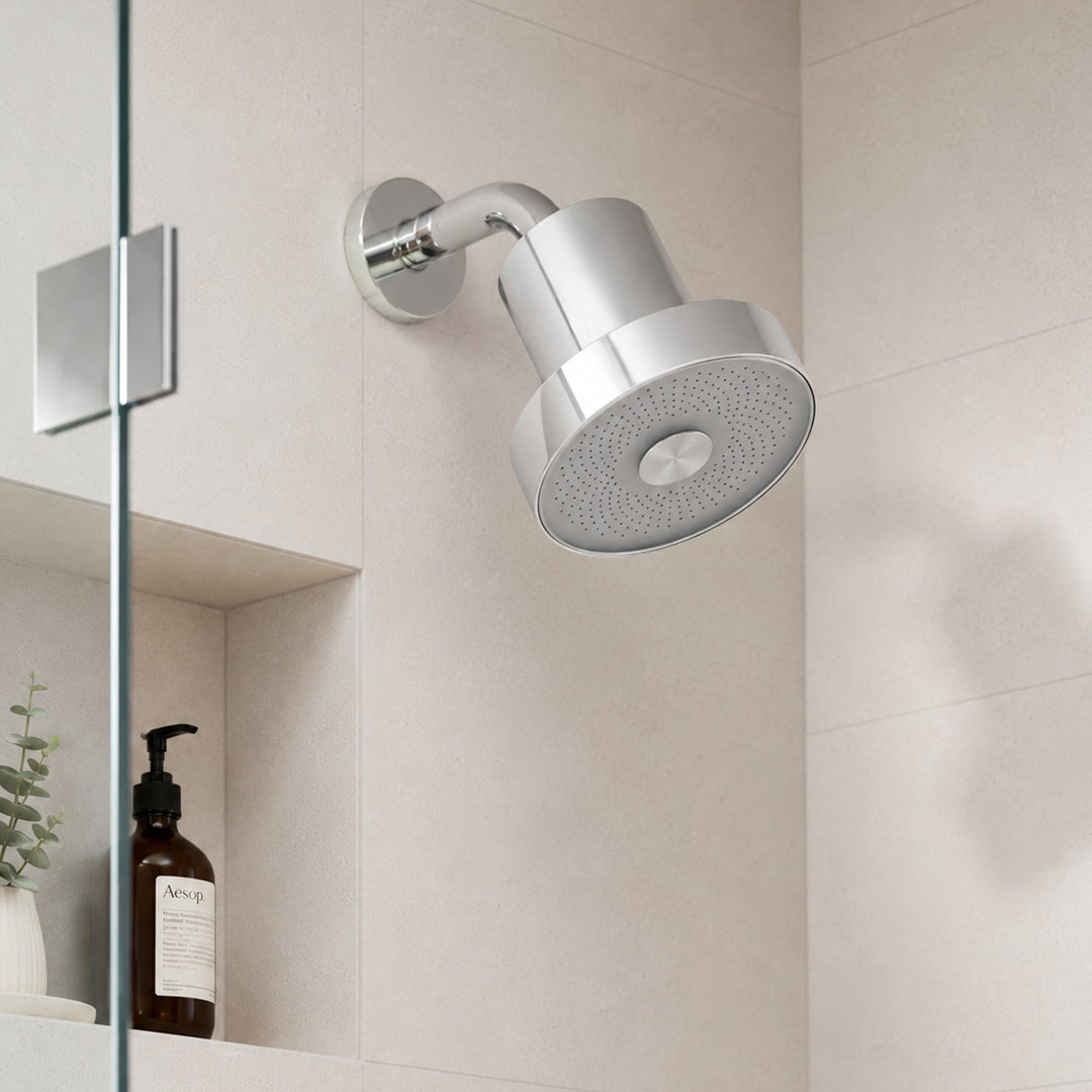 Silver filtering shower head installed on a modern bathroom wall